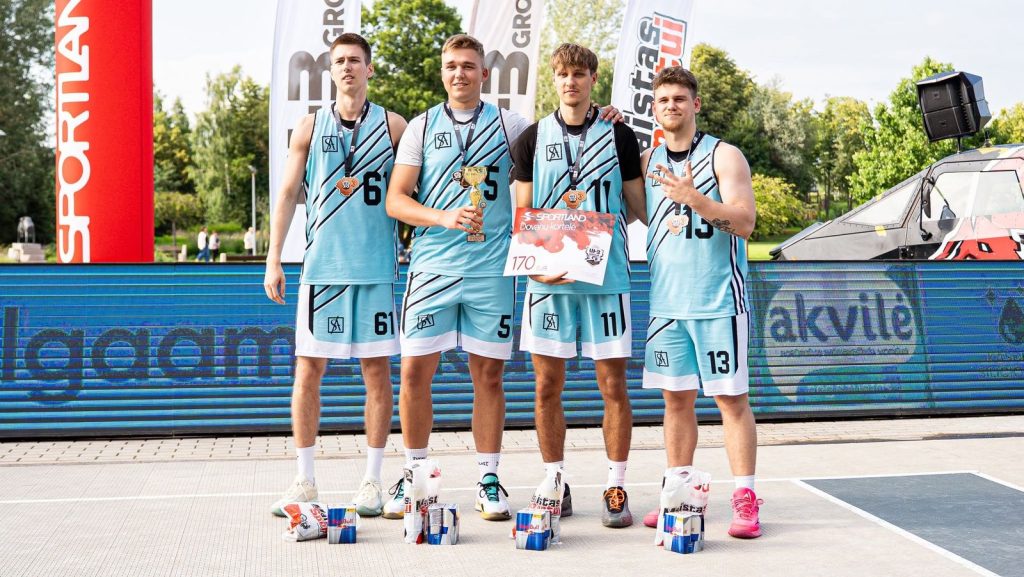Krepšinio komanda su SportArt apranga ir medaliais ant apdovanojimų pakylos